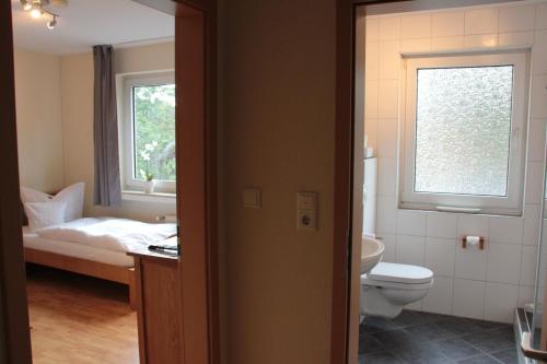 bagno con letto, servizi igienici e finestra di Restaurant Fischbeck´s a Großenkneten