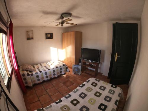 1 dormitorio con 2 camas y TV. en La Blanca de Aroche, en Aroche