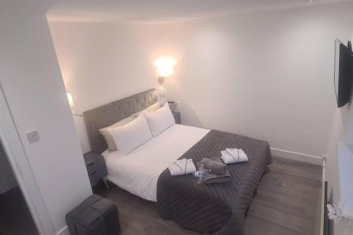 um pequeno quarto com uma cama com lençóis brancos em Stunning Refurbished 1 Bedroom, Harbour Apartment. em Ayr