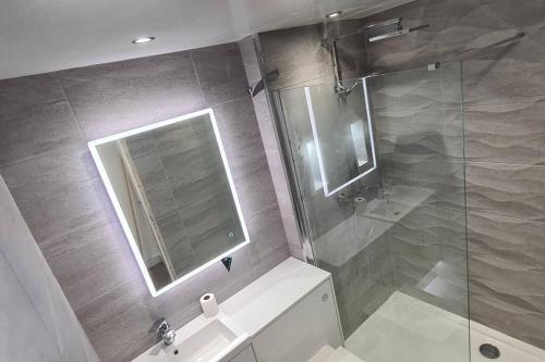 a bathroom with a shower and a sink and a mirror at Stunning Refurbished 1 Bedroom, Harbour Apartment. in Ayr