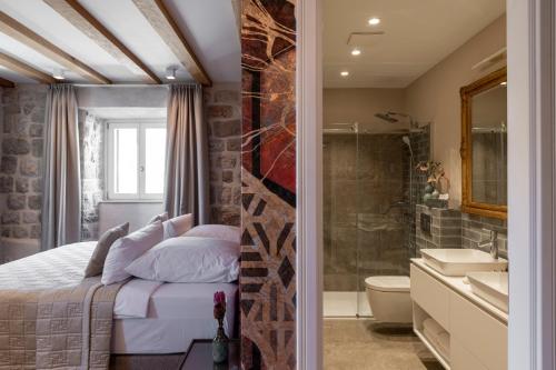a bedroom with a king sized bed and a bathroom at Sea Rocks Residence in Dubrovnik