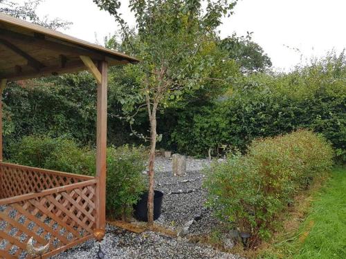 a garden with a wooden pavilion and a tree at Butterfly Cottage Retreat - Private Studio Getaway in Delvin