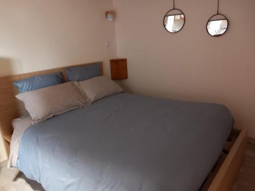 een slaapkamer met een bed met twee lampjes aan de muur bij Studio indépendant dans villa in Néffiès