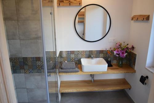 a bathroom with a sink and a mirror at Osada Dzikie Wino in Budzów