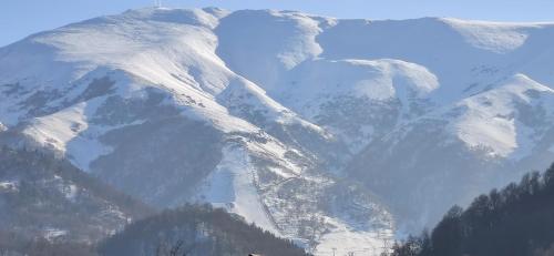 a snow covered mountain range with snow on it at Villa Bayern in Bakuriani in Bakuriani