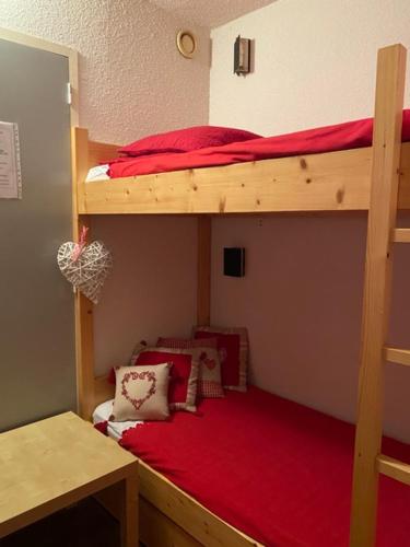 a bedroom with two bunk beds with red sheets at Studio Arc 2000 5 people in Arc 2000
