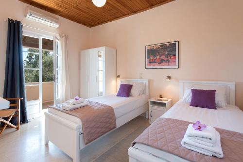 sypialnia z 2 łóżkami i fioletowymi poduszkami w obiekcie Villa Lofos w Kassiopi