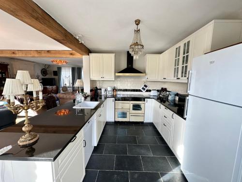 a kitchen with white cabinets and a white refrigerator at Maison Durbuy L'air du temps in Weris