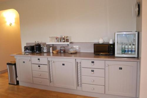 a kitchen with a counter with a microwave and a refrigerator at Hillview Lodge in Armagh