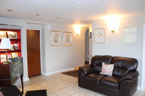a living room with a leather chair and a couch at Hillview Lodge in Armagh