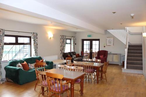a living room with tables and chairs and a couch at Hillview Lodge in Armagh