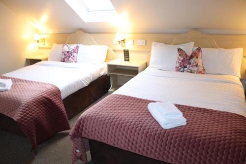 a hotel room with two beds and a window at Hillview Lodge in Armagh