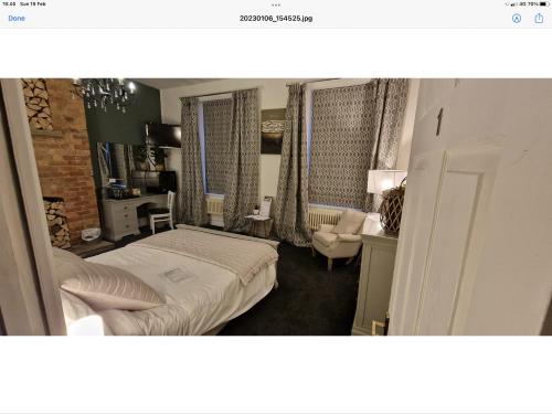 a bedroom with a bed and a chair and windows at Beautiful apartment in Sleaford in Sleaford
