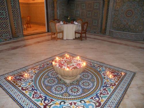 a table with a cake with lit candles on a rug at Dar Nador in Nador