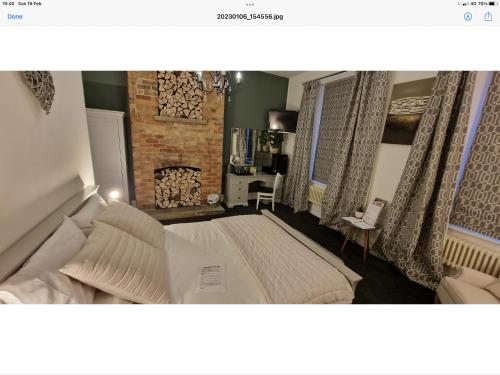 a bedroom with a large bed and a fireplace at Beautiful apartment in Sleaford in Sleaford