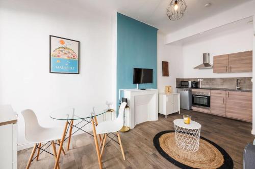 un salon avec une table et une cuisine dans l'établissement Au coeur du panier T2 climatisé et tout équipé, à Marseille