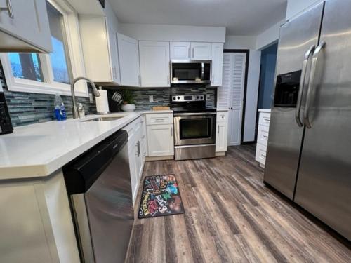 a kitchen with white cabinets and stainless steel appliances at Outdoor Sanctuary - 3 min walk to Silver Mtn in Kellogg