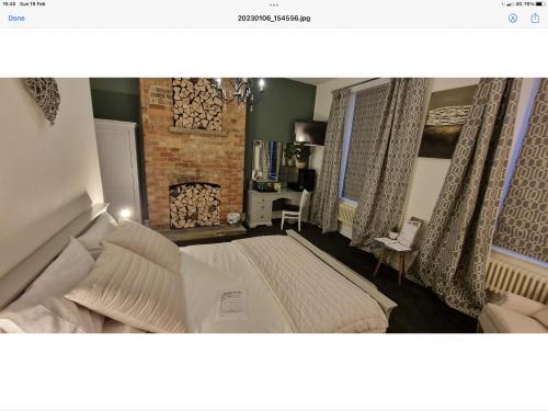 een slaapkamer met een groot bed en een open haard bij Beautiful apartment in Sleaford in Sleaford