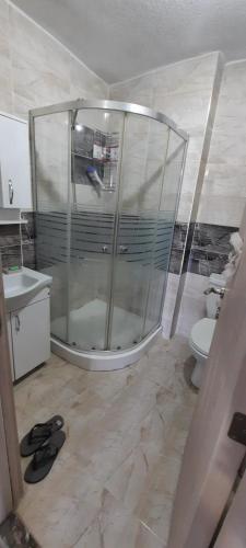 La salle de bains est pourvue d'une douche en verre et de toilettes. dans l'établissement omar, à Basaksehir