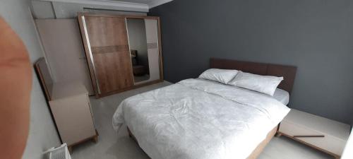 a small bedroom with a white bed and a mirror at omar in Basaksehir