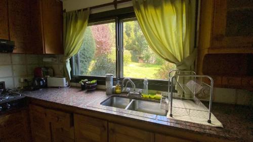 encimera de cocina con fregadero y ventana en Casa Las Violetas en San Carlos de Bariloche