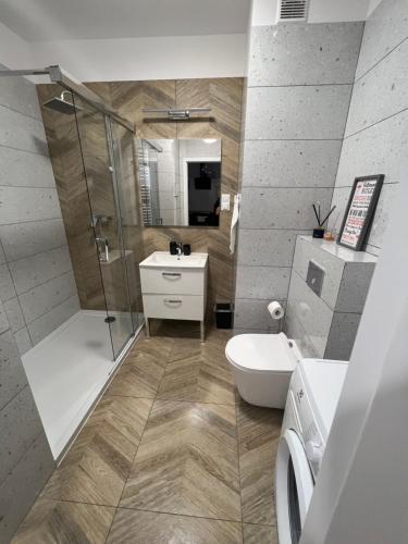 a bathroom with a shower and a toilet and a sink at Apartament Alexa na Tatarskiej A in Przemyśl