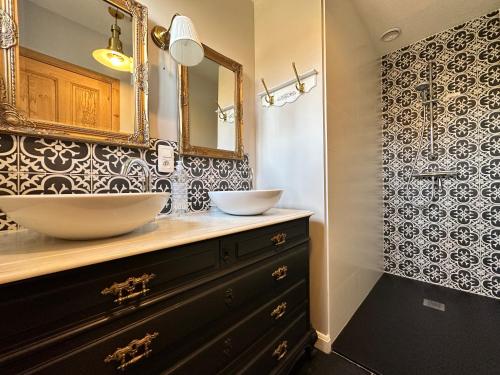 a bathroom with two sinks and a mirror at Maison Durbuy L'air du temps in Weris