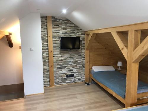 um quarto com uma cama e uma televisão numa parede de tijolos em Dom ul. Otrocz Nowy 1 