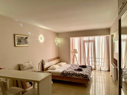 a bedroom with a bed and a table and a window at Light Apartments in Gudauri