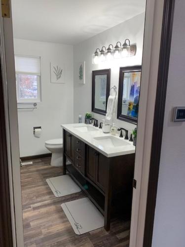 a bathroom with a sink and a toilet and a mirror at Outdoor Sanctuary - 3 min walk to Silver Mtn in Kellogg