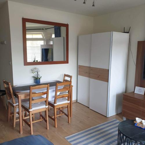 a dining room with a table and a refrigerator at Magyartenger Apartman Balatonlelle in Balatonlelle
