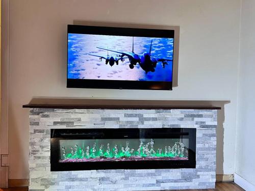 a television above a fireplace with a military plane on the screen at MountForest in Shoreline