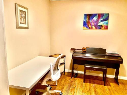 a room with a piano and a desk with a laptop at MountForest in Shoreline