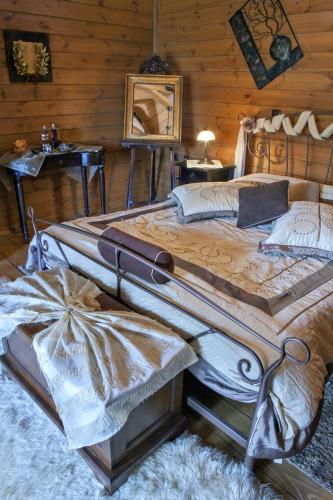a large bed in a room with wooden walls at Feggarognemata Suites in Ano Trikala