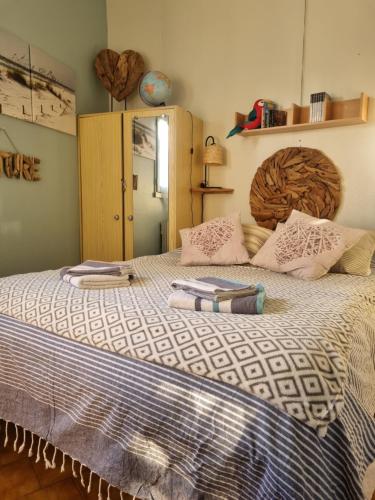 une chambre avec un grand lit avec deux serviettes dessus dans l'établissement Torreilles plage: villa atypique bord de mer méditerranée, à Torreilles