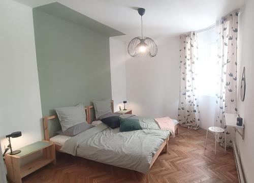 a bedroom with a bed and a pendant light at Apartment Balabanov in Varna City