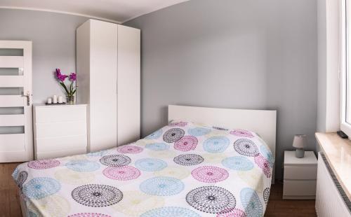 a bedroom with a bed with a polka dot bedspread at Marywilska apartment in Warsaw