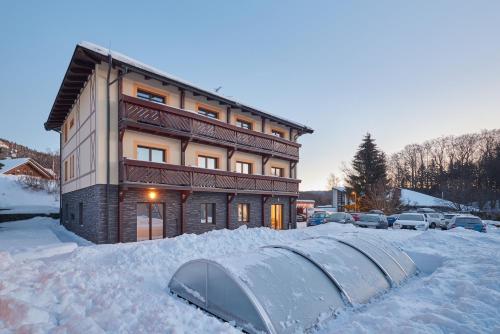 a building covered in snow with a tunnel in front at Residence Ruth in Janske Lazne