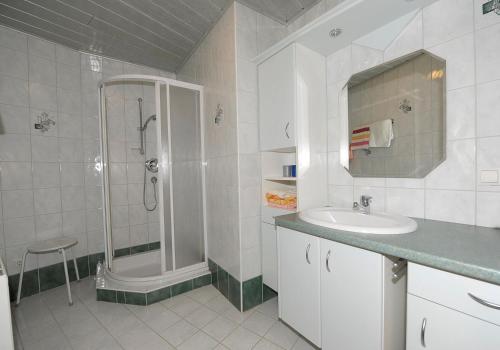 a white bathroom with a shower and a sink at Ursprunghof in Zeutschach