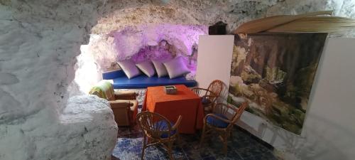 une chambre avec une table et des chaises dans une grotte dans l'établissement Mirasierra, à Bedmar