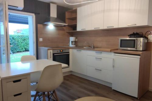 eine Küche mit weißen Schränken und einem Tisch mit Stühlen in der Unterkunft Studio Bidehegia in Souraïde