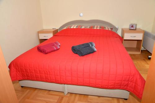 a red bed with two bags on top of it at Korali Apartment in Ohrid
