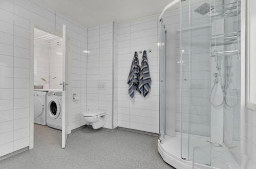 a bathroom with a toilet and a washing machine at Din hjem! Mitt i by1. Gratis parkering!! in Narvik