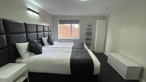 a bedroom with a large bed with a large headboard at Hosted By Ryan - 1 Bedroom Apartment in Liverpool