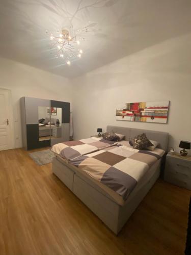 Un dormitorio con una cama grande y una lámpara de araña. en Biljka, en Viena
