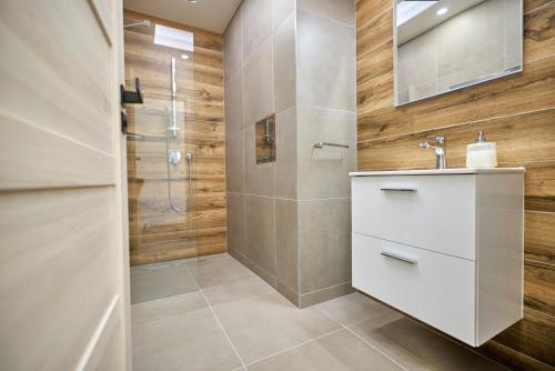 ein Bad mit einem Waschbecken und einer Dusche in der Unterkunft Apartmán pod Plešivcem in Abertamy