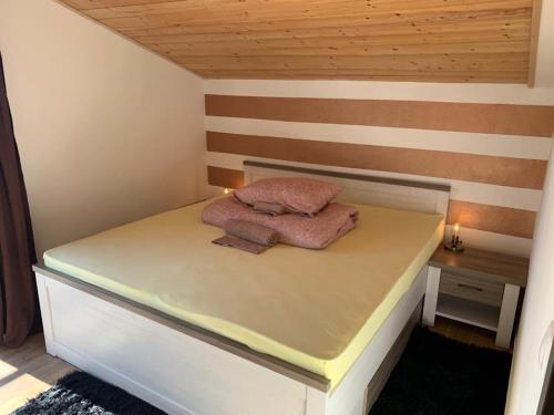 a bed with two pillows on it in a room at Apartmany Rogoznica in Rogoznica