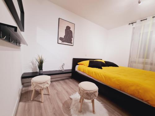 1 dormitorio con 1 cama amarilla y 2 taburetes en Casa Rosina - Una caramella, nel nucleo, ai piedi della Verzasca-, en Gordola