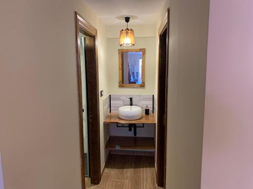 ein Bad mit einem Waschbecken und einem Spiegel in der Unterkunft "CHALET A ESTRENAR" MIRADOR DE LA VENTOSA-Potes in Ojedo