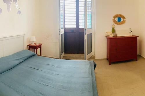 a bedroom with a blue bed and a wooden dresser at Casa Gigé in Ustica